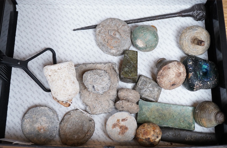 A collection of Roman and other ancient lead weights in various forms bearing various cast marks, together with a cast iron pointer the handle in the form of a head